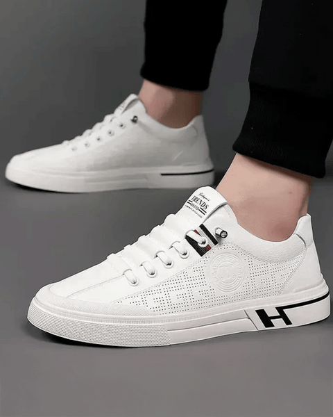 Detalhe lateral do tênis branco com perfurações e acabamento refinado inspirado no estilo europeu.